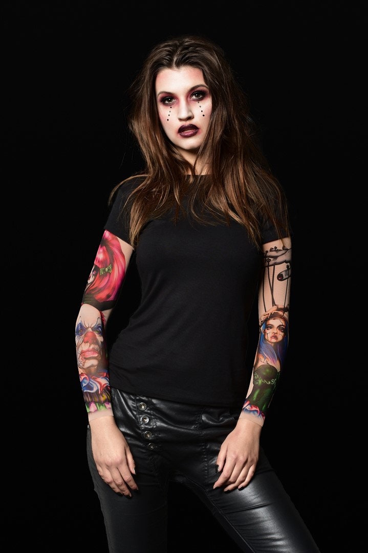 Woman posing in the Black Mirror Circus Halloween T-shirt, showcasing the detailed clown and circus tattoo prints, great for Halloween or as a standout statement shirt.