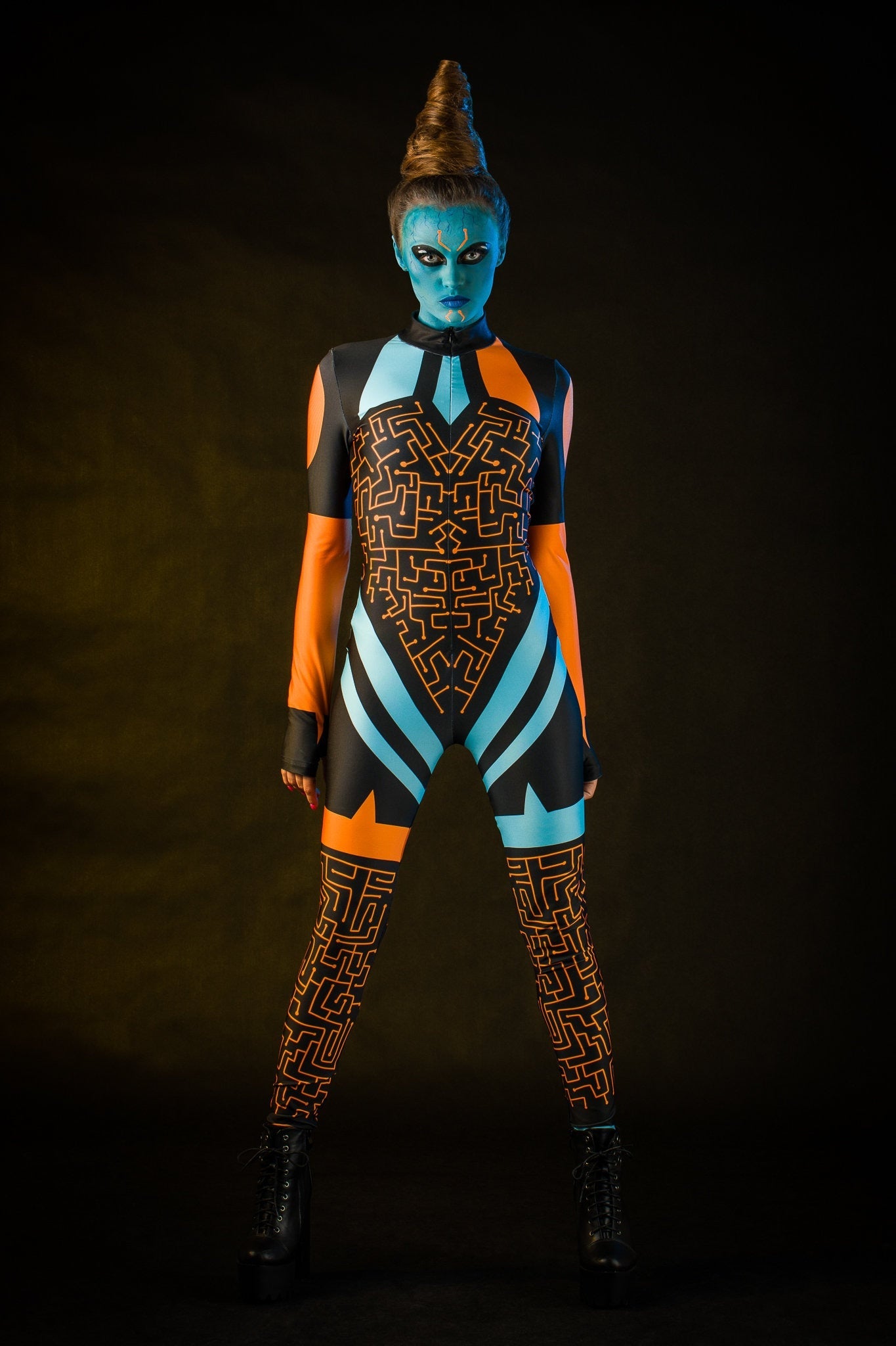 Woman posing in the Blue Alien Halloween costume, showcasing the sleek blue jumpsuit and tattoo effect, great for Halloween or as a standout festival outfit.