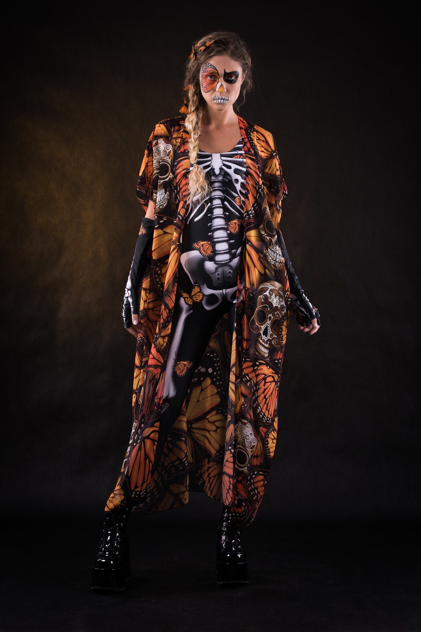 Woman posing in the Orange Butterflies Skeleton jumpsuit with kimono, highlighting the detailed butterfly and skeleton design, great for Halloween parties or as a standout festival outfit.