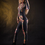 Woman wearing the Flower Skeleton costume, full-body skeleton catsuit with bold orange, yellow, and green floral accents, perfect for Halloween or Day of the Dead festivities.