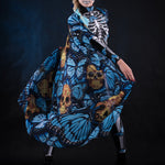 Woman posing in the Blue Monarchy Butterflies Halloween cape, highlighting the dramatic flow and vibrant butterfly details, great for a Day of the Dead-inspired look or festival wear. Woman dancing.