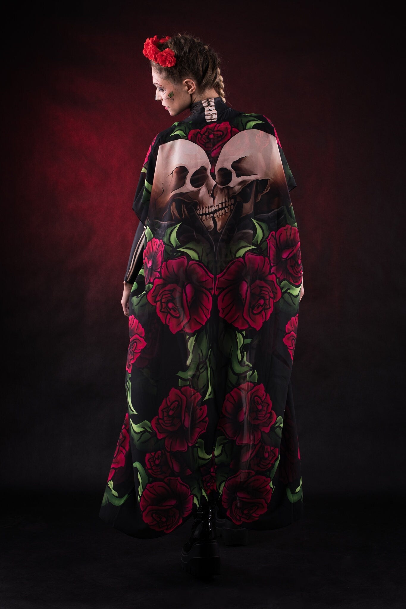 Woman wearing the Lady Death kimono Halloween cape, featuring a black cape with skull and rose accents, perfect for Halloween or Day of the Dead events.