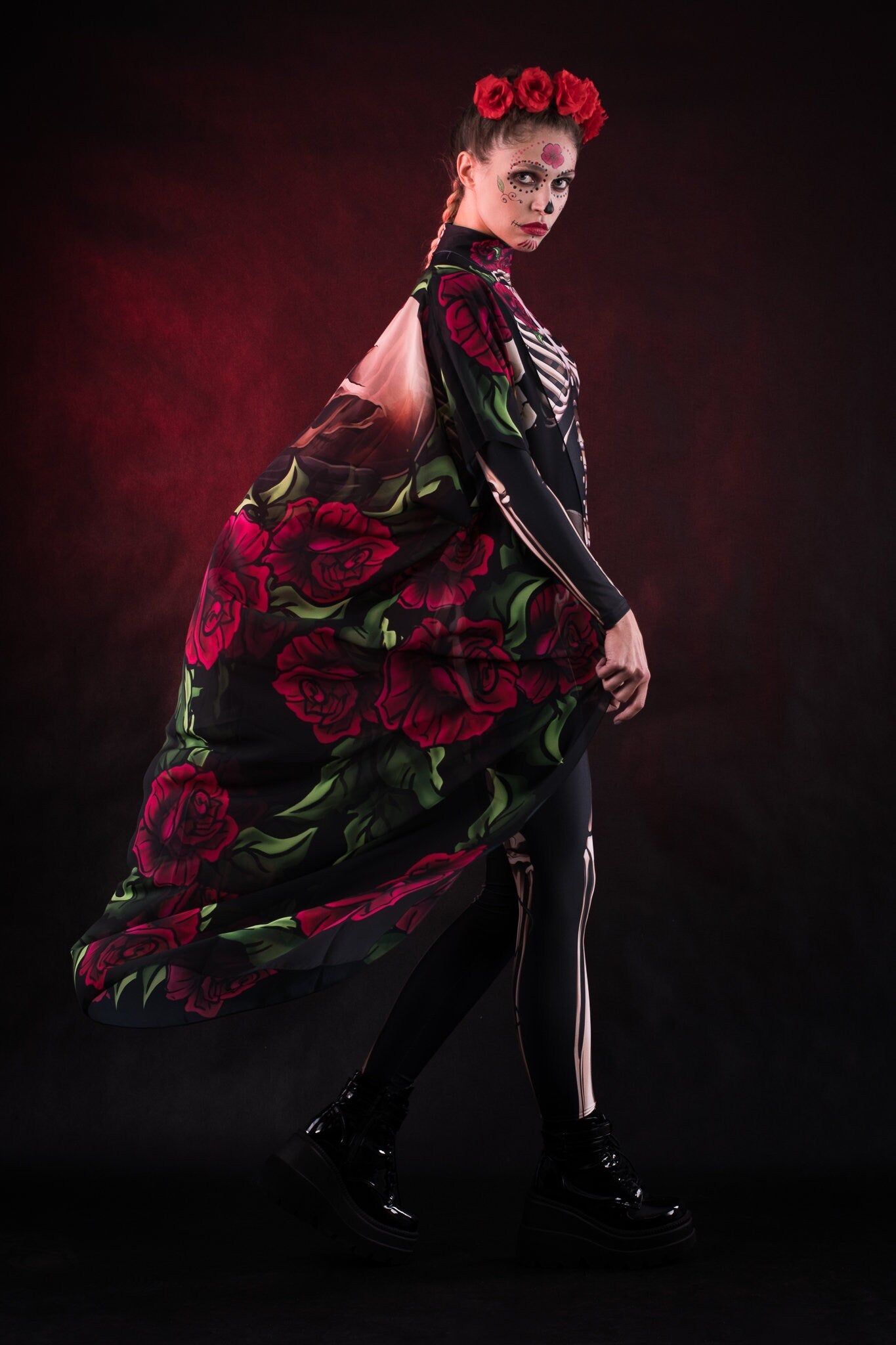 Woman wearing the Lady Death kimono Halloween cape, featuring a black cape with skull and rose accents, perfect for Halloween or Day of the Dead events.