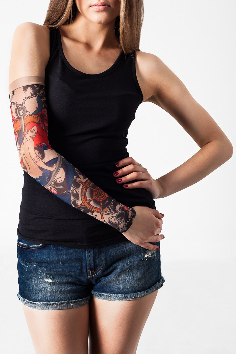 Rękaw z tatuażem seksownej syreny w bajkowym stylu, z różowymi włosami i niebieskim ogonem – na damskiej ręce, widok z przodu