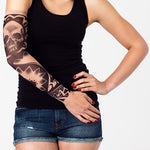 Rękaw z tatuażem czarnej czaszki i motywów tribalowych – na damskiej ręce, widok z przodu