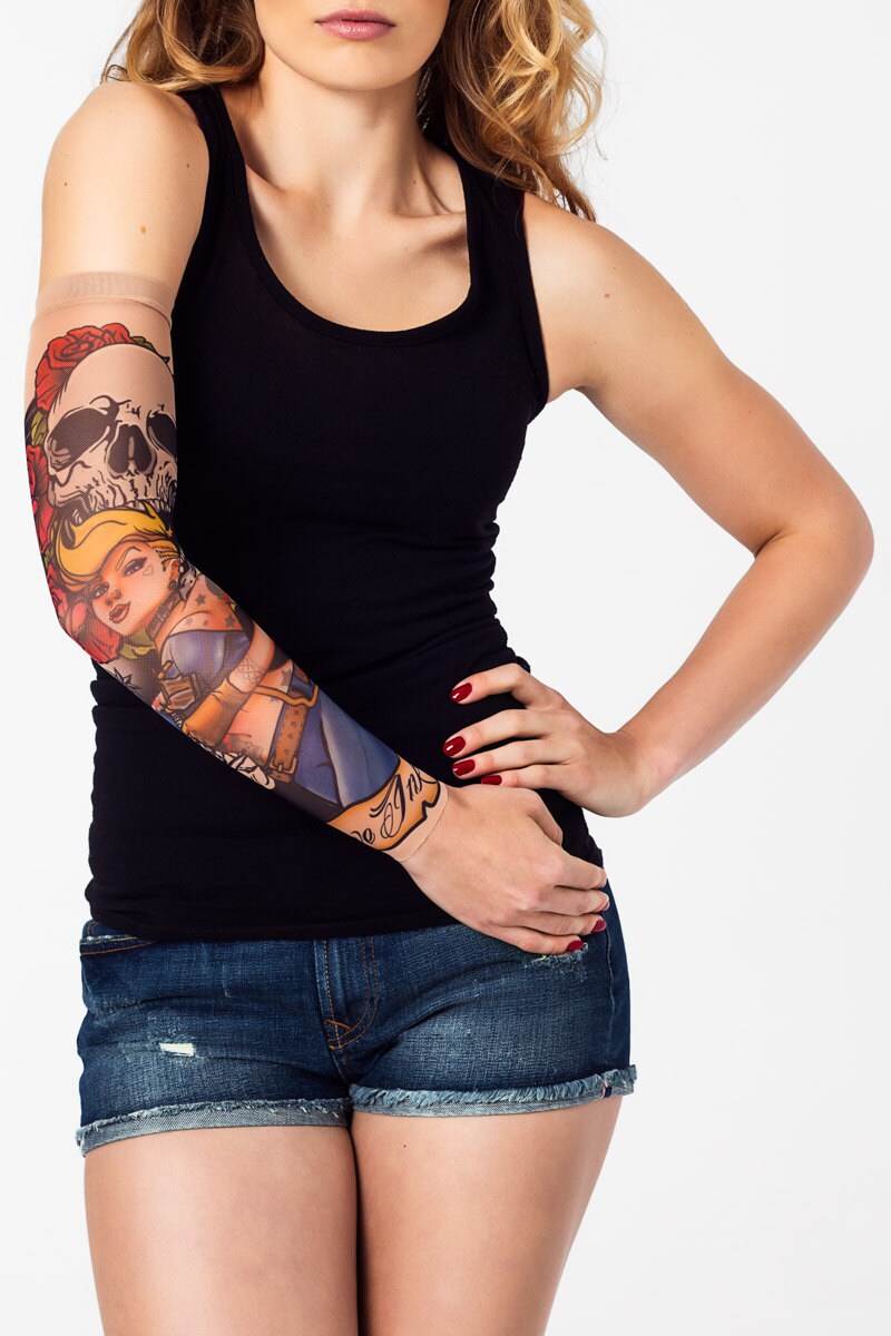 Rękaw z tatuażem seksownej tatuatorki i dużej czaszki – na damskiej ręce, widok z przodu