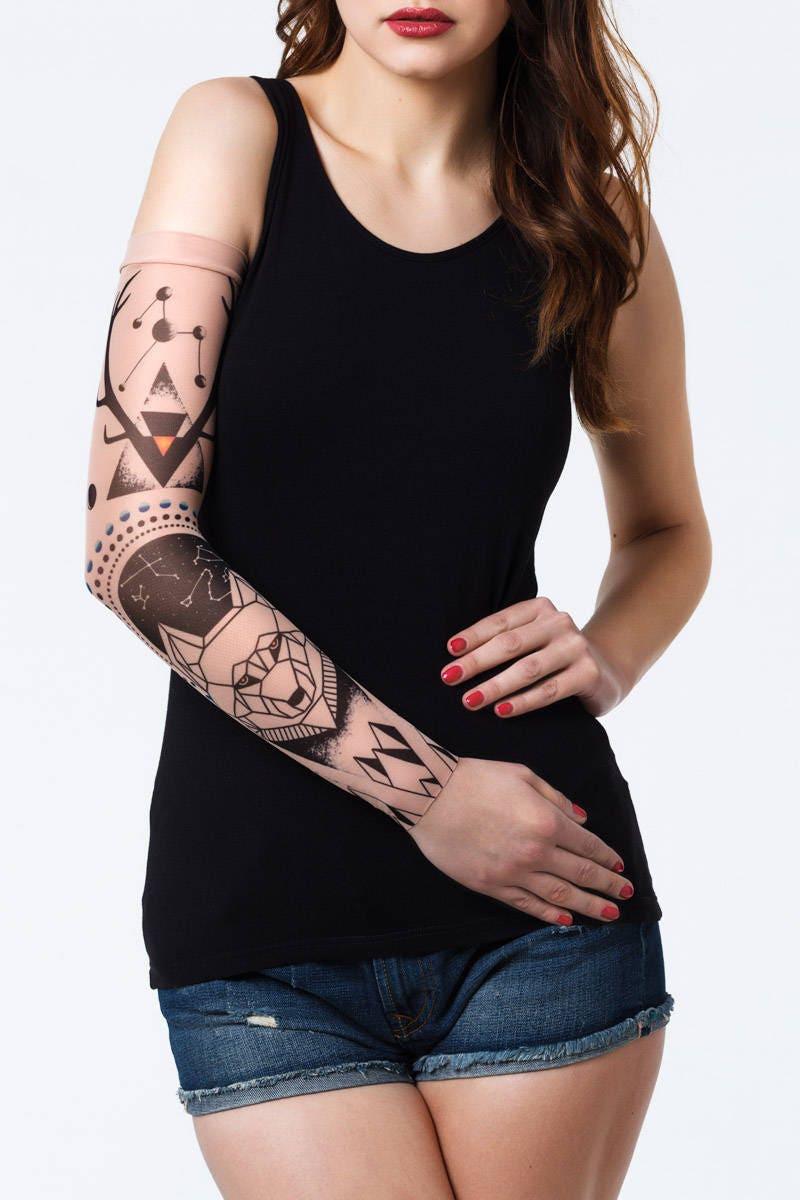 Rękaw z tatuażem geometrycznego wilka i rogów jelenia – na damskiej ręce, widok z przodu