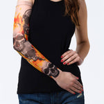 Rękaw z tatuażem czaszek i ognia w czarno-pomarańczowej kolorystyce – na damskiej ręce, widok z przodu