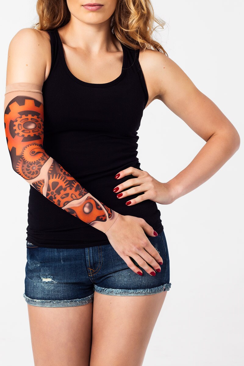 Rękaw z tatuażem kolorowych, pomarańczowych trybów maszyny – na damskiej ręce, widok z przodu