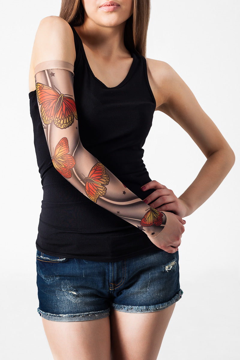 Rękaw z tatuażem w żółto-pomarańczowe motyle na damskiej ręce – widok z przodu